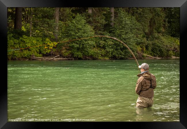 A man hooked into a fish while fly fishing on a deep green river. Framed Print by SnapT Photography