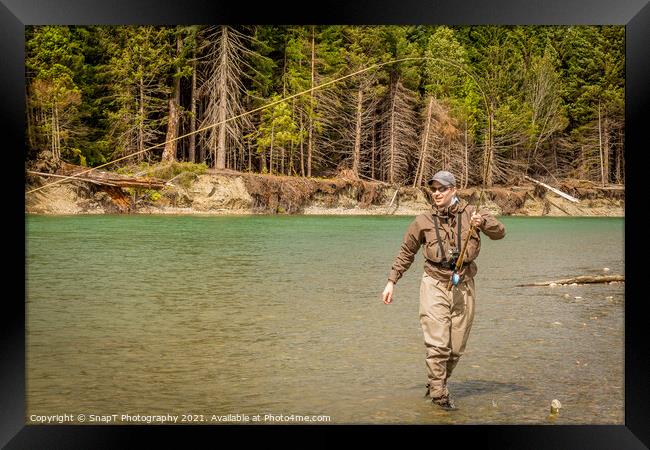 A sport fly fisherman hooked into a salmon on a river in British Columbia Framed Print by SnapT Photography