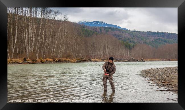 A fly fisherman hooked into a big fish in a river with the rod bent Framed Print by SnapT Photography
