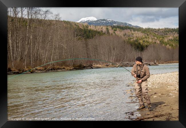 A fly fisherman hooked into a big fish in a river  Framed Print by SnapT Photography