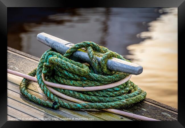 Rope tied around a metal bollard mooring on a wooden jetty Framed Print by SnapT Photography