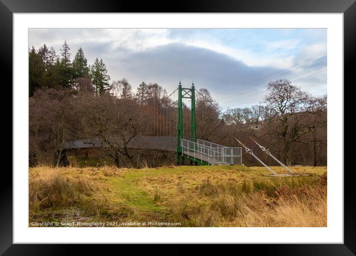 A green wooden suspension bridge on a trail leading into a forest woodland Framed Mounted Print by SnapT Photography
