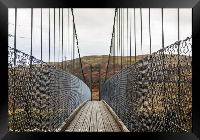 View across a wooden suspension bridge in the Scottish highlands Framed Print by SnapT Photography