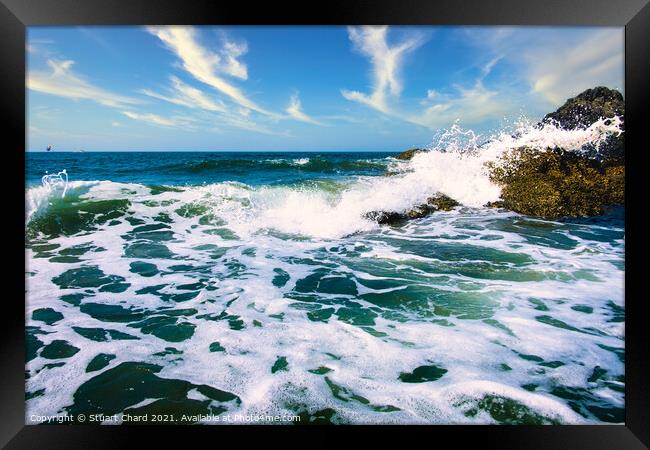 Waves crashing over the rocks with surf and spray Framed Print by Stuart Chard