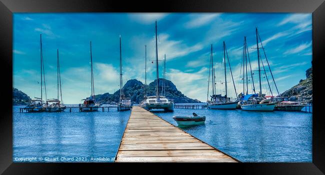 Bay with boats on a jetty Framed Print by Stuart Chard