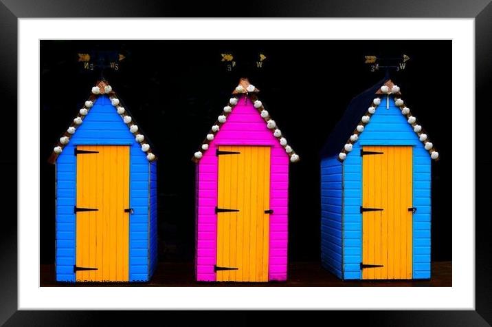 Three brightly painted sheds with weather vanes on top Framed Mounted Print by Peter Wiseman