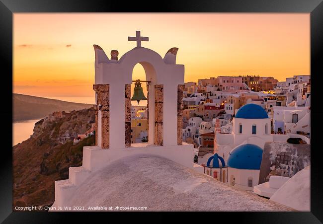 Blue domed churches and bell tower facing Aegean Sea with warm sunset light in Oia, Santorini, Greece Framed Print by Chun Ju Wu