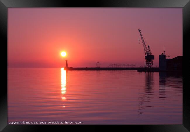 Port crane at sunset Framed Print by Nic Croad