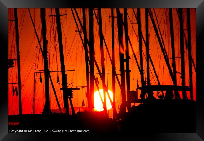 Sunset through silhouetted yacht masts Framed Print by Nic Croad
