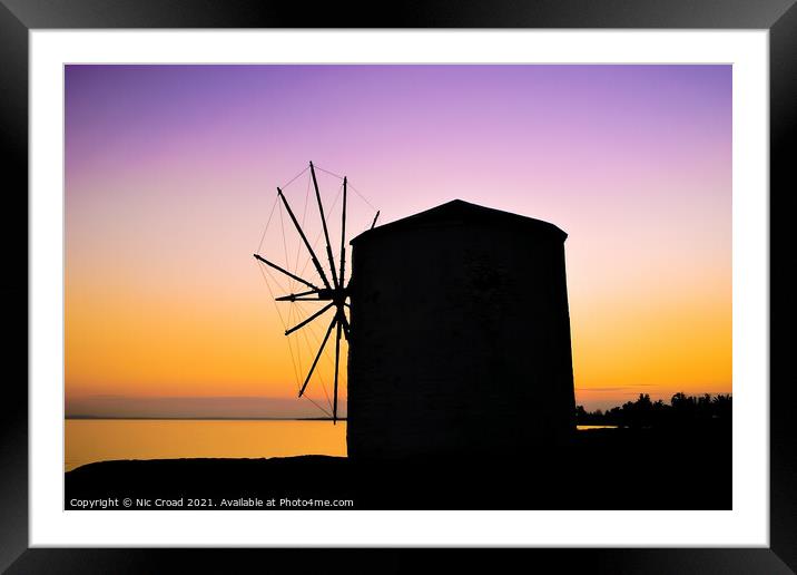Silhouette of a Greek windmill at sunset Framed Mounted Print by Nic Croad