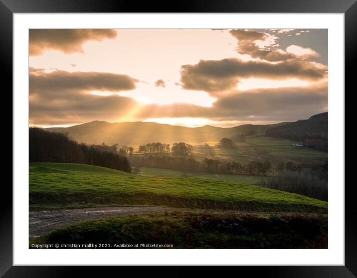 Sun rays over Scottish hills Framed Mounted Print by christian maltby