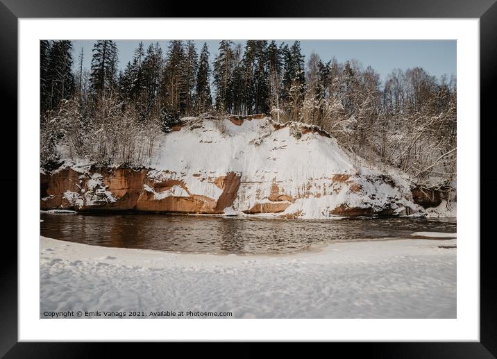 rock cliff and cave by the river Gauja in the Gauja National Park in Latvia in winter with beautiful sun through the forest Framed Mounted Print by Emils Vanags