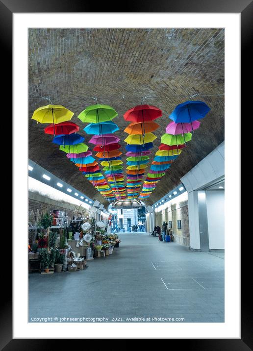 An array of colourful umbrellas at London Bridge Station. Framed Mounted Print by johnseanphotography 