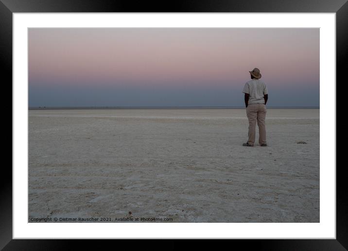 Dusk in Makgadikgadi Salt Pan - Black Man Gazing at Horizon Framed Mounted Print by Dietmar Rauscher