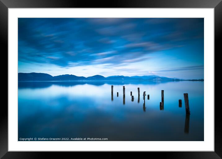 Remains of a wooden jetty in a blue lake Framed Mounted Print by Stefano Orazzini