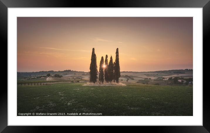 Sunset landscape in Alta Maremma. Rolling hills and cypress trees Framed Mounted Print by Stefano Orazzini