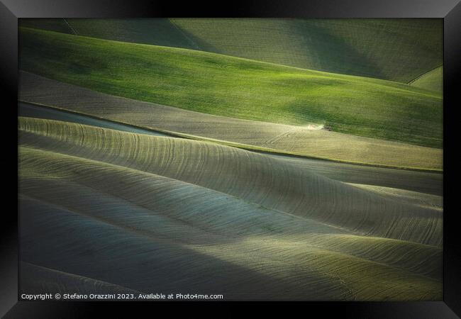 Tractor plowing the fields in Tuscany sunset. Vescona, Siena. Framed Print by Stefano Orazzini