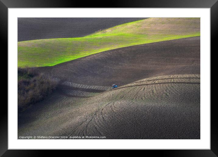 Tractor plowing the fields in Tuscany. Volterra, Italy Framed Mounted Print by Stefano Orazzini