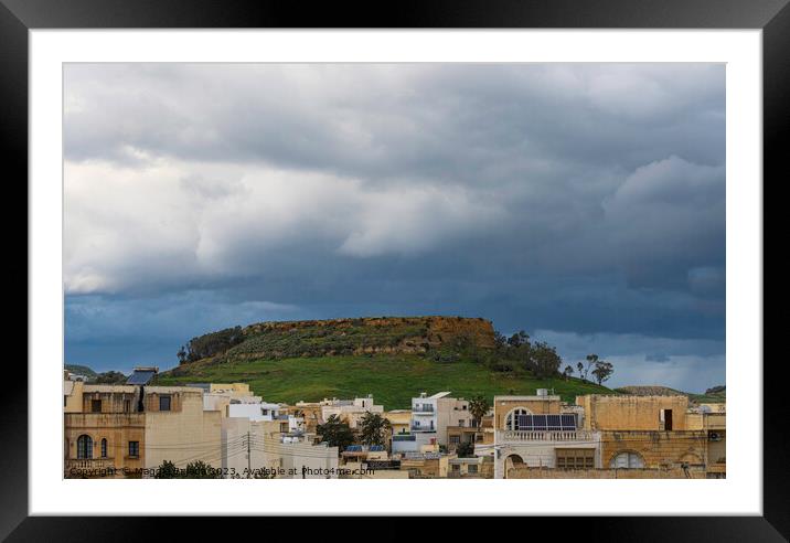 Storm over the hill with buildings, Gozo Island. Framed Mounted Print by Maggie Bajada