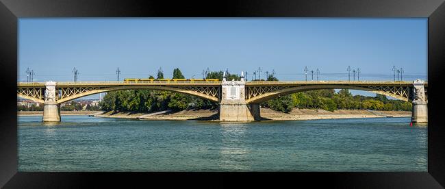 Yellow bridge with tram crossing over Danube River, Budapest, Hungary. Framed Print by Maggie Bajada