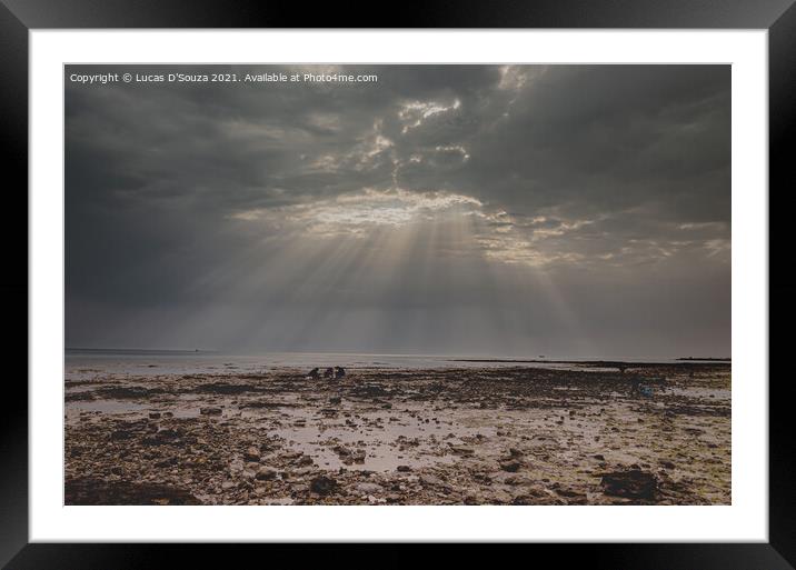Sunrays through a gap in the overcast sky with black clouds with Framed Mounted Print by Lucas D'Souza