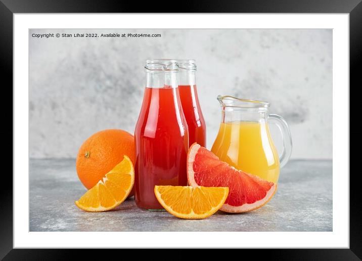 Glass pitchers of grapefruit juice with slices of orange fruits Framed Mounted Print by Stan Lihai