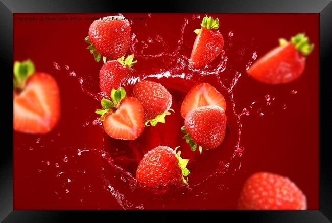 Strawberry falling into the lot of juice Framed Print by Stan Lihai