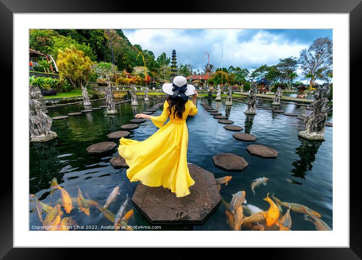 Woman standing in pond with colorful fish at Tirta Gangga Water  Framed Mounted Print by Stan Lihai