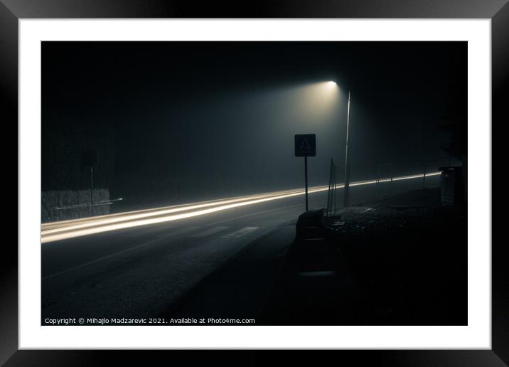 Dark foggy city street at night with a light trail Framed Mounted Print by Mihajlo Madzarevic