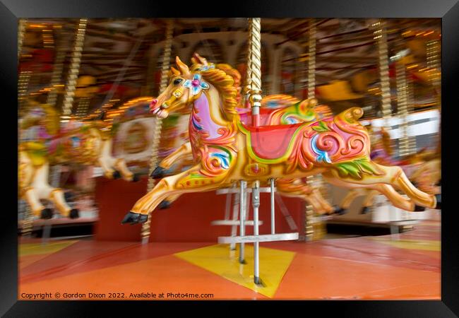 Carousel horses in action at the seaside Framed Print by Gordon Dixon
