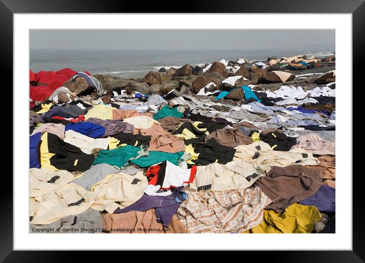 Freshly laundered clothes and fabrics drying on rocks by the sea at Mumbai, India Framed Mounted Print by Gordon Dixon