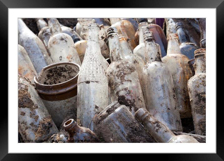 A selection of old glass bottles excavated from a building site in Surrey Framed Mounted Print by Gordon Dixon