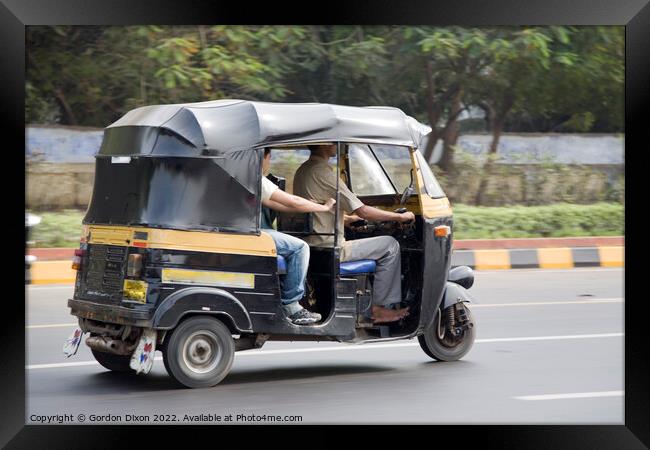 Autorickshaw driving down a road with passenger - Delhi, India Framed Print by Gordon Dixon