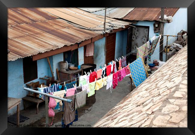 Bright colours in the laundry drying at a shanty town in Accra, Ghana Framed Print by Gordon Dixon
