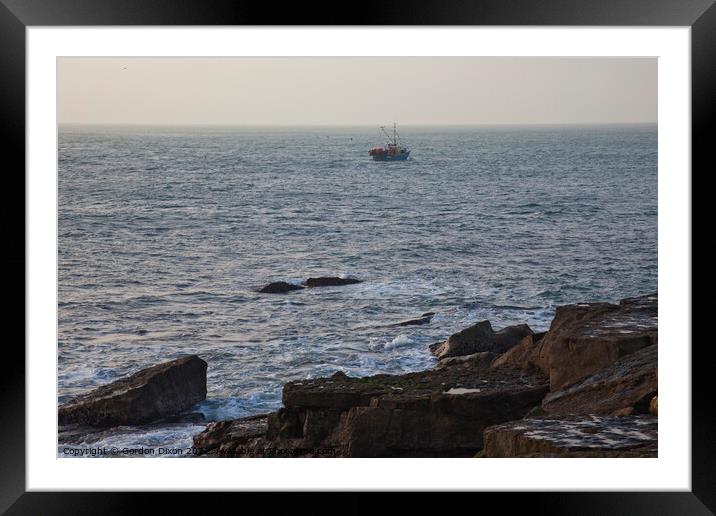 A fishing trawler heads out to sea passing the treacherous rocks off Portland Bill Framed Mounted Print by Gordon Dixon