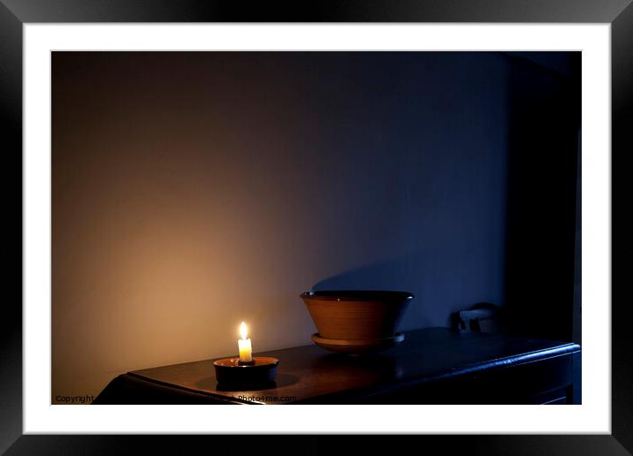 A single candle lights a vintage layout room as darkness falls Framed Mounted Print by Gordon Dixon