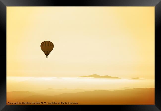 Hot air balloon over mountains in dawn mist Framed Print by Catalina Morales
