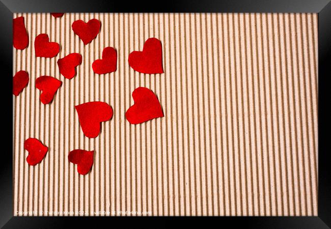 Red color paper hearts on a brown cardboard Framed Print by Turgay Koca