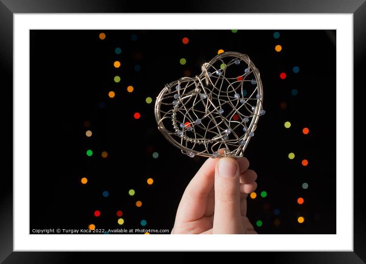 Heart shaped metal cage on bokeh light background Framed Mounted Print by Turgay Koca