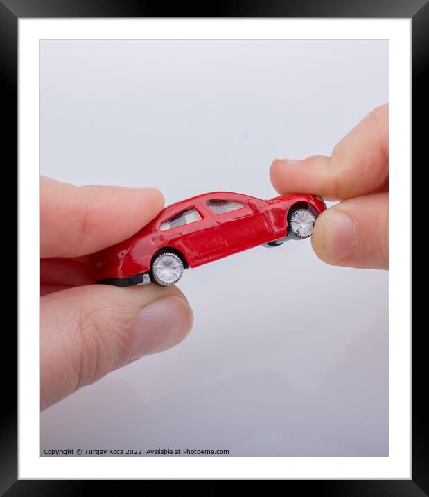 Child giving out little toy car Framed Mounted Print by Turgay Koca