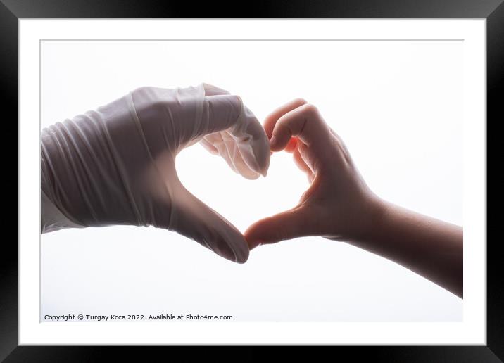 Putting on latex  gloves on hands for protection make heart shap Framed Mounted Print by Turgay Koca