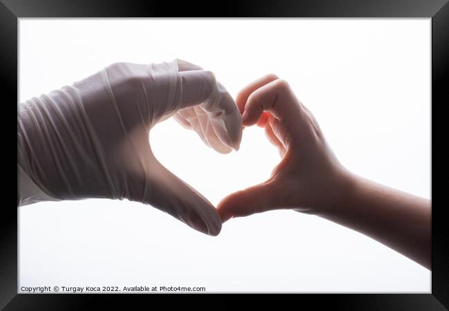 Putting on latex  gloves on hands for protection make heart shap Framed Print by Turgay Koca