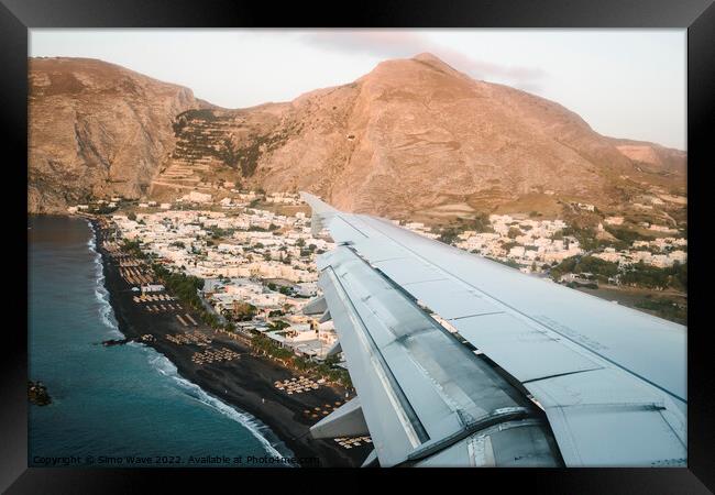 Airplane is landing in Santorini Island Framed Print by Simo Wave