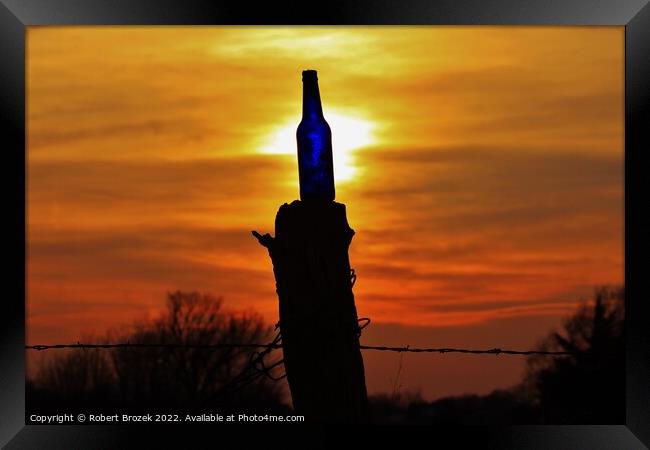 Sunset with a bottle on a fence post with sky. Framed Print by Robert Brozek