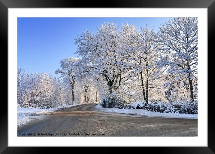 View of a snow-covered country road in winter with sunshine and  Framed Mounted Print by Michael Piepgras