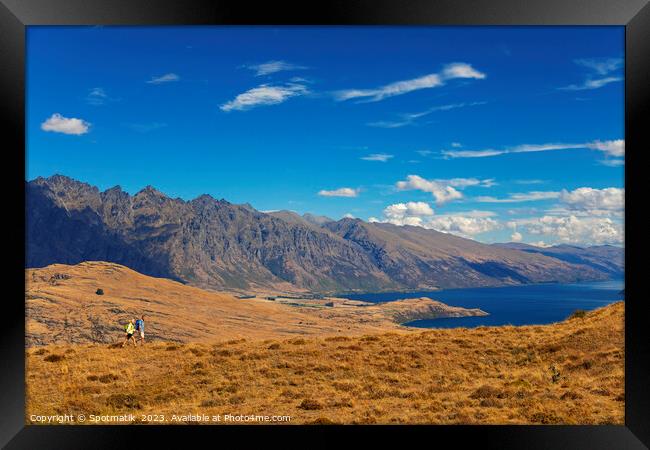 Mature backpacking couple hiking in remote mountainous landscape Framed Print by Spotmatik 