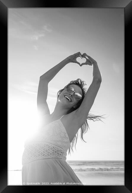 Bohemian girl dancing on beach showing heart sign Framed Print by Spotmatik 