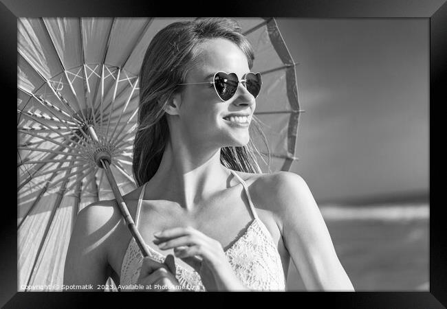 Smiling American hippy chic with parasol on beach Framed Print by Spotmatik 