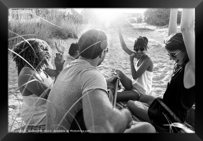 Outdoor fun on beach friends enjoying guitar music Framed Print by Spotmatik 