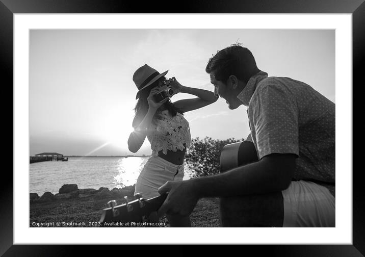 Ethnic couple playing guitar by ocean at sunset Framed Mounted Print by Spotmatik 